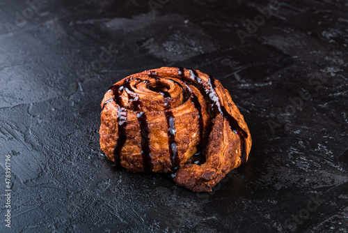 Freshly baked tasty bun on a dark table. Tasty baked goods straight from the bakery. Black background.