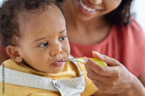 Baby Feeding. Closeup Of Cute Little Black Infant Boy Eating From Spoon