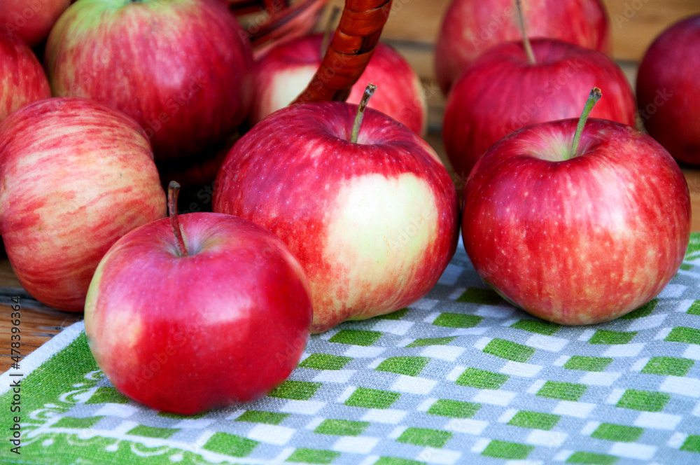 Apples are scattered from the basket onto a green napkin. . High quality photo Apples are scattered from the basket onto a green napkin. . High quality photo