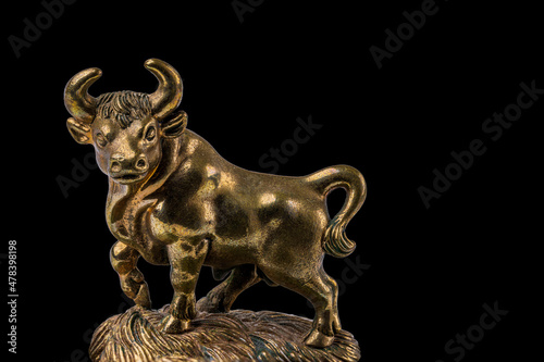 Closeup view of bronze figure of Taurus cattle sign isolated on black  background.