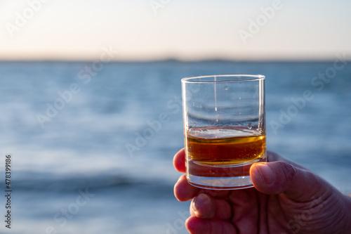 Obraz na plátně Drinking single malt Scotch whisky at sunset with sea, ocean or river view, priv