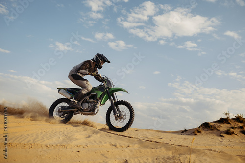Fototapeta Naklejka Na Ścianę i Meble -  Professional motocross rider sliding down sand hill