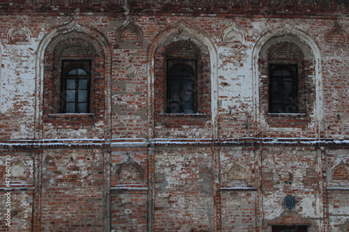 Wall of old red brick house with arch windows
