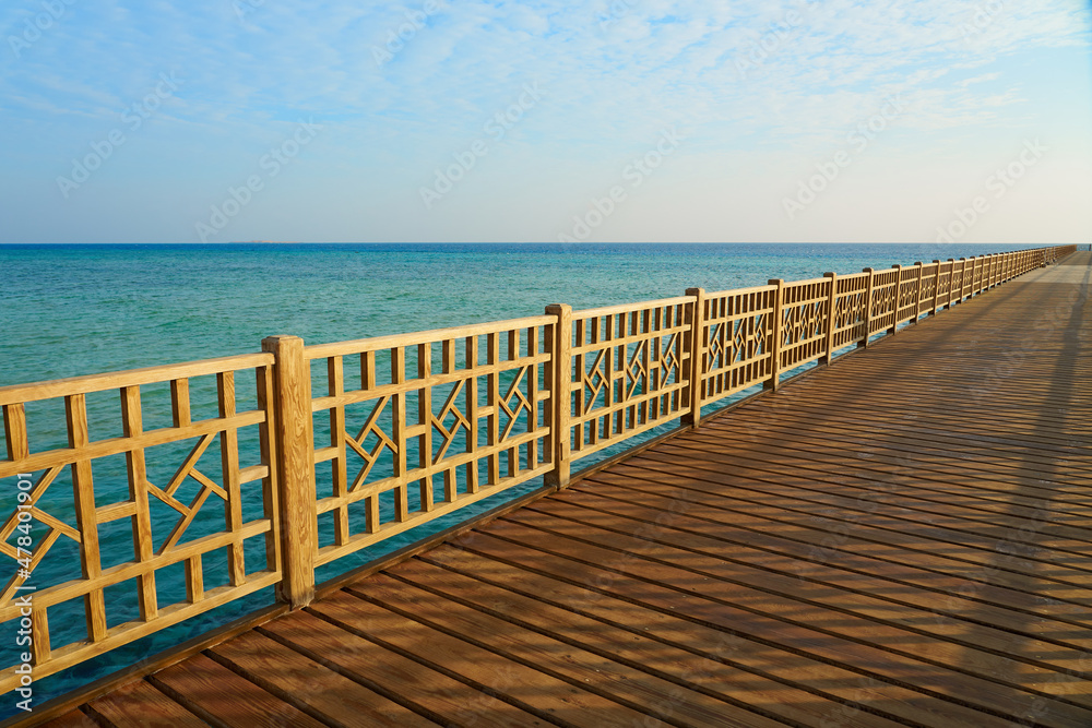 A wooden pier on the shores of the Red Sea with a horizon in the background.