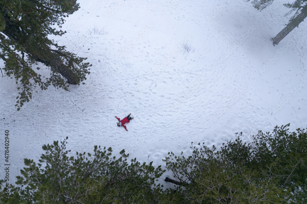 Drone aerial of woman wearing warm clothing lie down at snow in winter. Troodos cyprus Drone aerial of woman wearing warm clothing lie down at snow in winter. Troodos cyprus