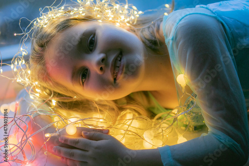 Little girl with christmas lights. High quality photo