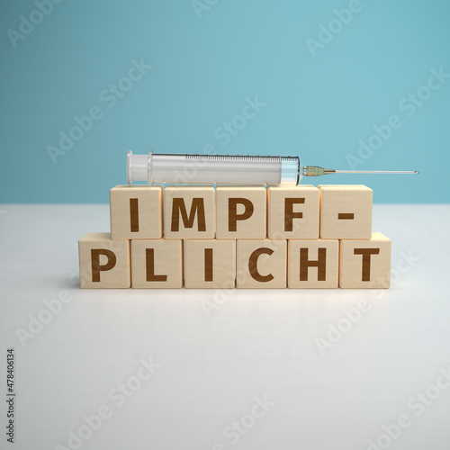 The German word Impfpflicht (mandatory vaccination) built from letters on wooden cubes. photo