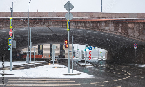 Red light at traffic lights at pedestrian crossing in winter during snowfall