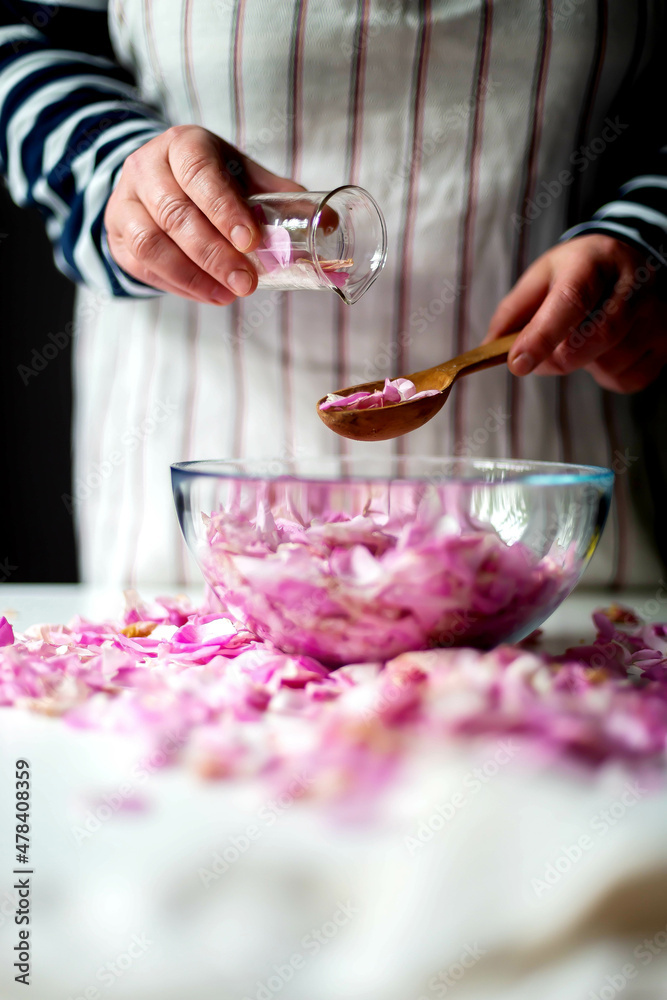 Woman Making Pink Rose Petal Jam in kitchen Woman Making Pink Rose Petal Jam in kitchen
