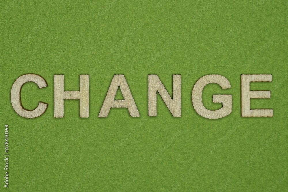 gray word change from small wooden letters on a green table gray word change from small wooden letters on a green table