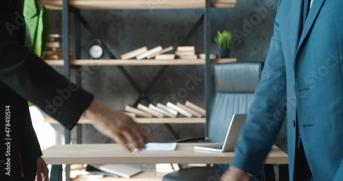 Closeup hands of top managers shaking hands with each other at modern office. Two businessmen in suits greeting each other at office with handshaking