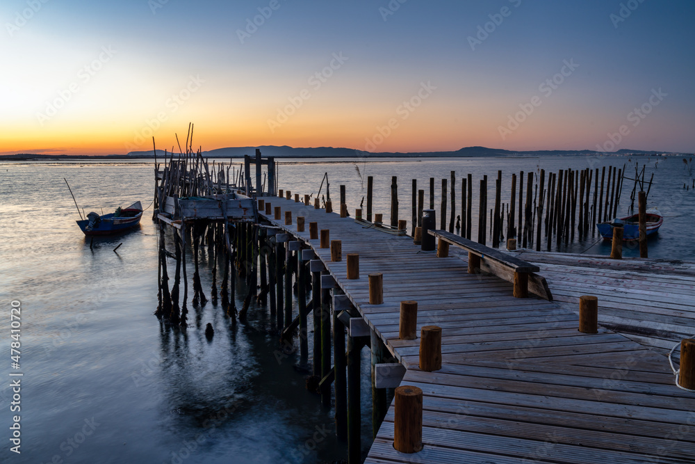 Fototapeta premium Comporta wooden stilt pier at sunset in Setúbal, Portugal. 