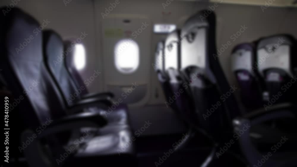 Defocused shot of traveling by air. Rows of seats cabin in the interior airplane. Point of view as passenger from seat. Travelers boarding a plane. Inside of aircraft. Blurred background in the scene Defocused shot of traveling by air. Rows of seats cabin in the interior airplane. Point of view as passenger from seat. Travelers boarding a plane. Inside of aircraft. Blurred background in the scene