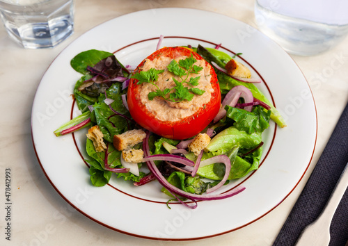 Deliciously tomato stuffed with tuna on a pillow of salad, french cuisine