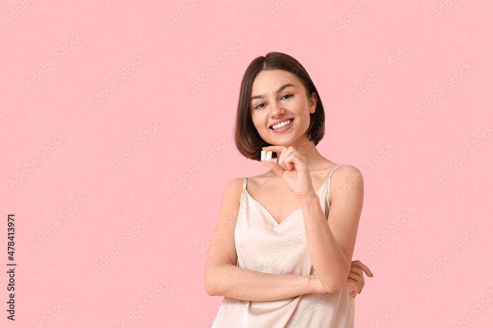 Young woman in pajamas and with chewing gum on color background Young woman in pajamas and with chewing gum on color background