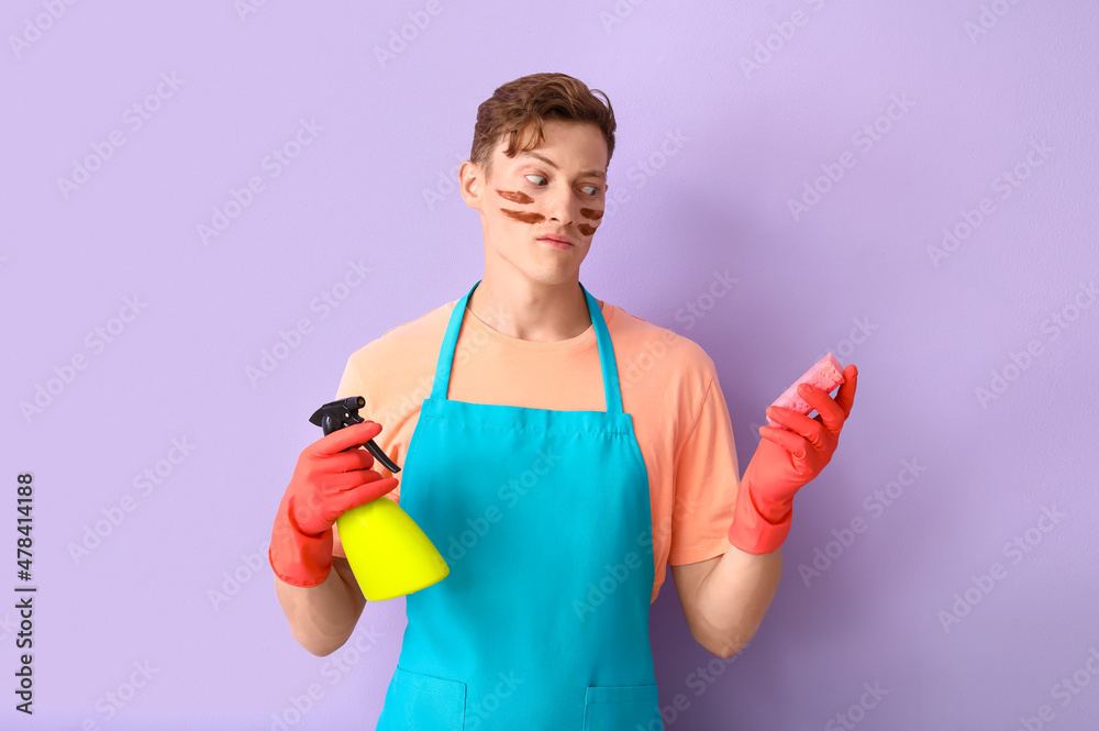Handsome man with cleaning sponge and detergent on lilac background Handsome man with cleaning sponge and detergent on lilac background