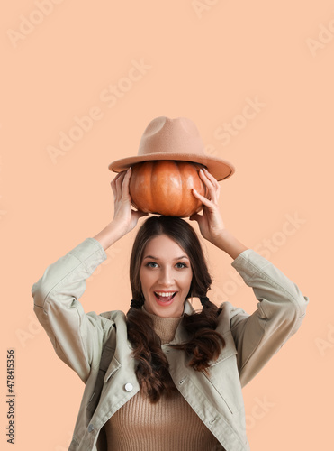 Happy woman holding pumpkin...