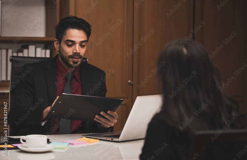 Closeup shot of Millennial Indian Asian professional successful executive bearded male businessman manager entrepreneur in formal suit sitting smiling shaking hands with businesswoman colleague
