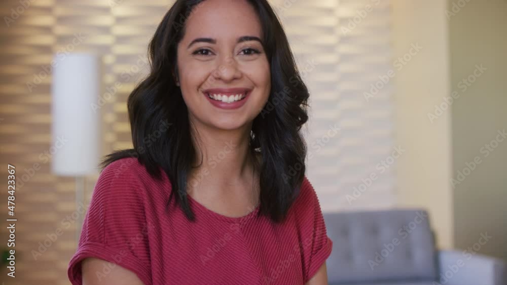 Portrait of a woman turning toward camera and smiles in a living room Portrait of a woman turning toward camera and smiles in a living room