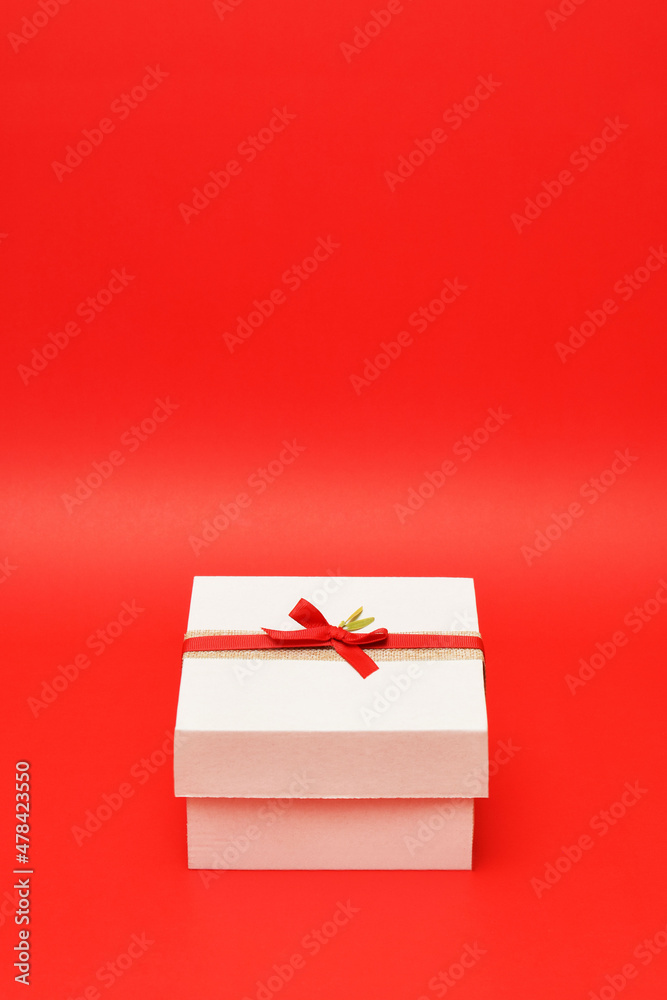 Caja de regalo color blanco sobre un fondo rojo. Espacio para texto en la parte superior. Caja de regalo color blanco sobre un fondo rojo. Espacio para texto en la parte superior.