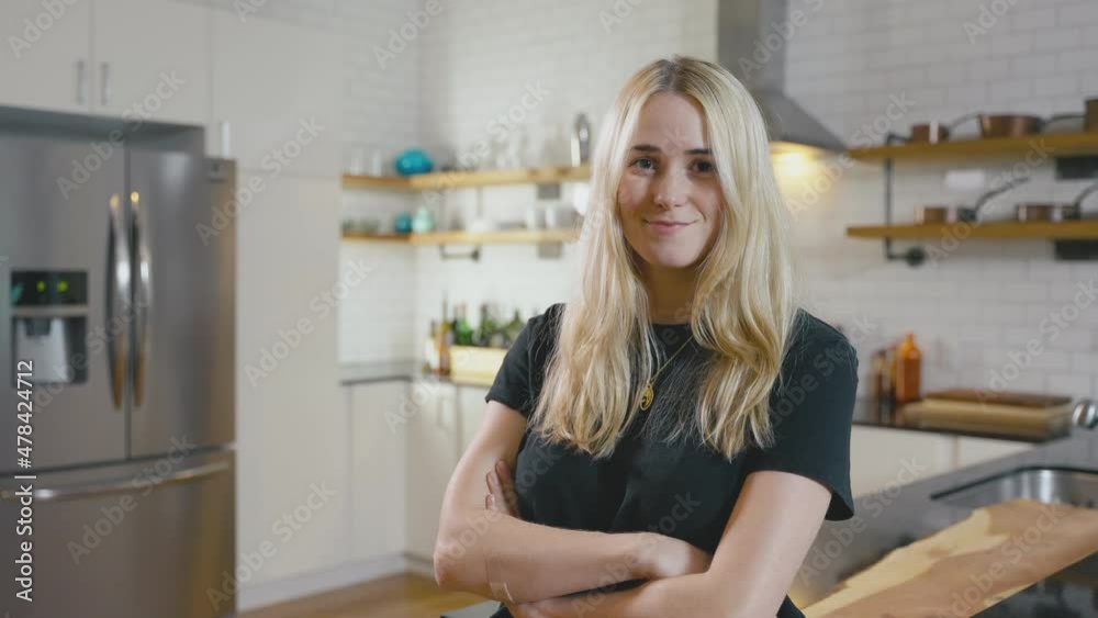 Portrait of a young Caucasian woman standing in kitchen looking at camera confidently. Portrait of a young Caucasian woman standing in kitchen looking at camera confidently.