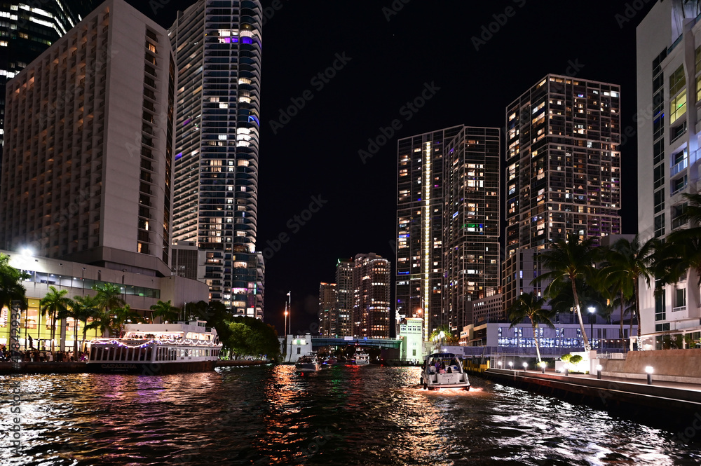 Obraz premium Entrance to Miami River with brightly lit residential towers reflected in Biscayne Bay at night in Miami, Florida.
