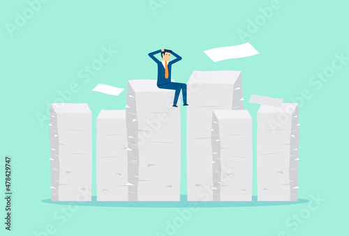 Tired businessman sitting on many documents, clutching his head with work, overwork and paper document around