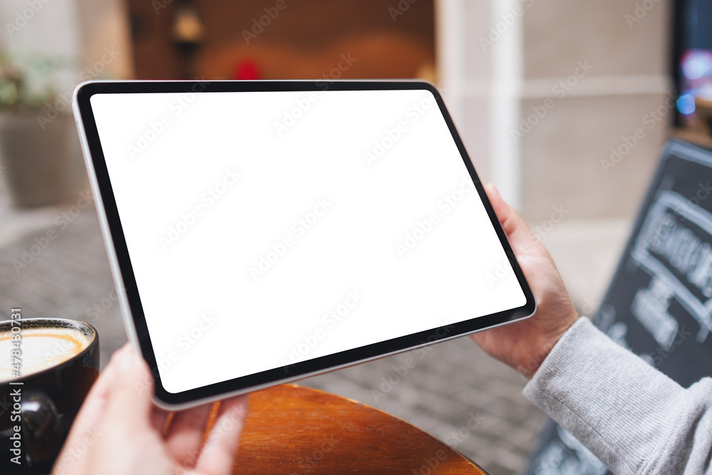 Mockup image of a woman holding digital tablet with blank white desktop screen in the outdoors - obrazy, fototapety, plakaty 