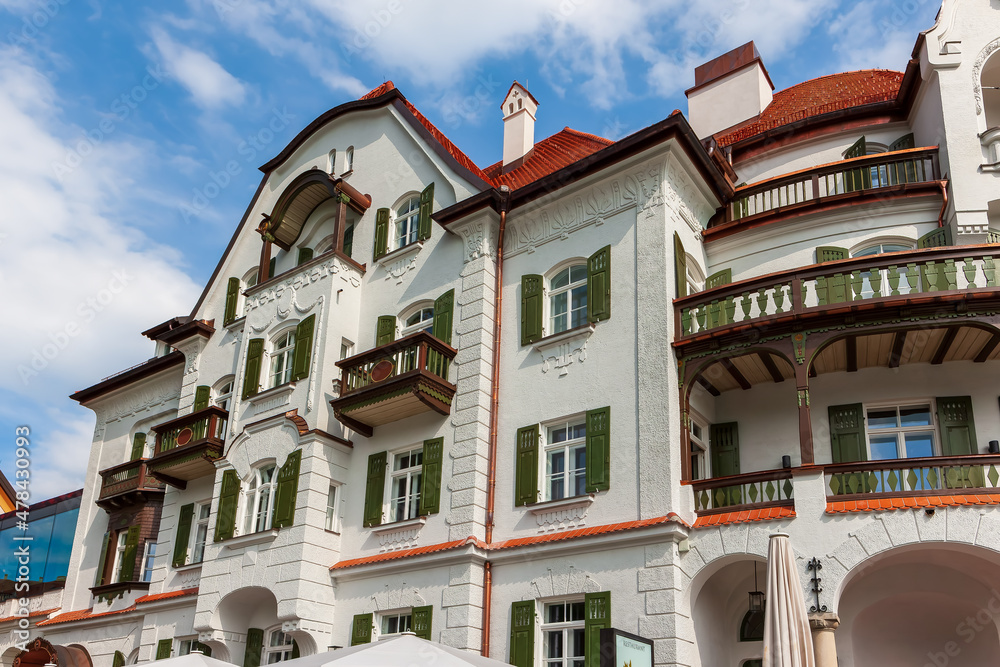 Obraz premium Typical Bavarian house with red tiled roof, balconies and wooden shutters near Fussen in Bavaria, Germany