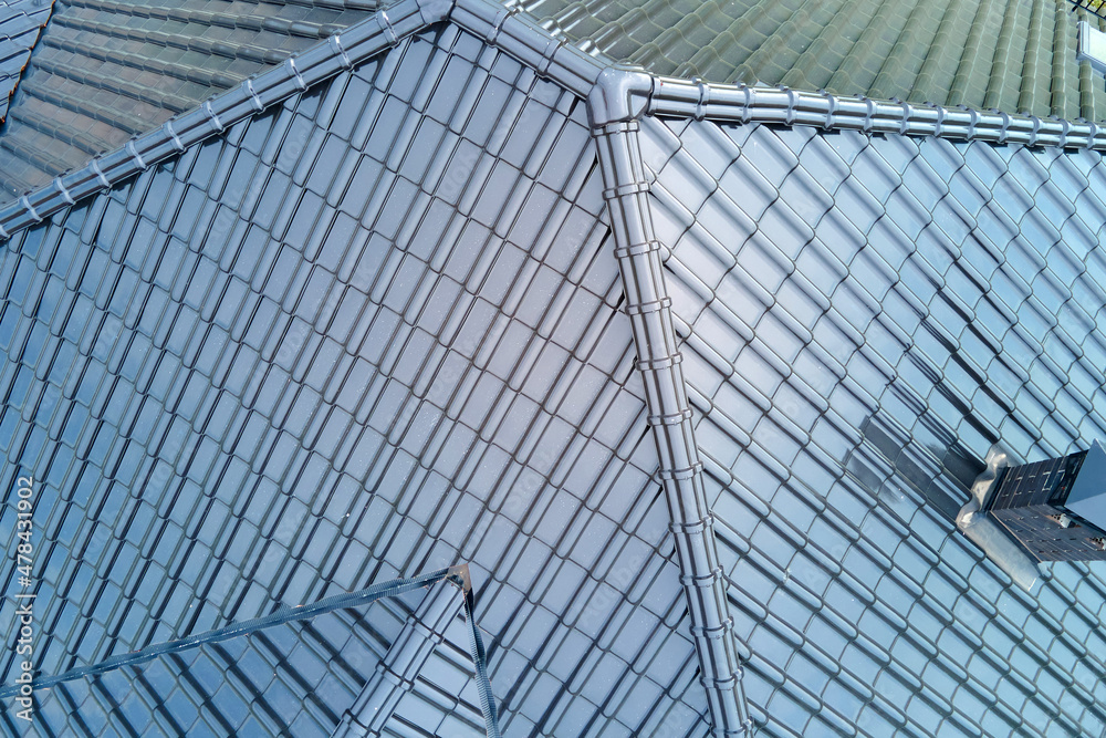Closeup of house roof top covered with shiny ceramic shingles Closeup of house roof top covered with shiny ceramic shingles