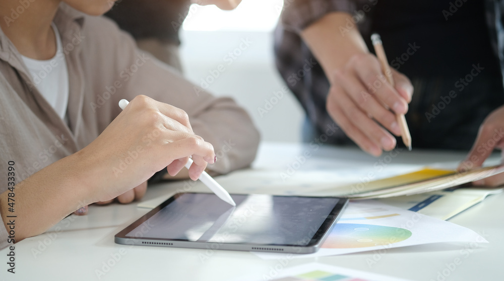 Cropped shot businesswoman holding digital tablet and working with her colleague in office. Cropped shot businesswoman holding digital tablet and working with her colleague in office.