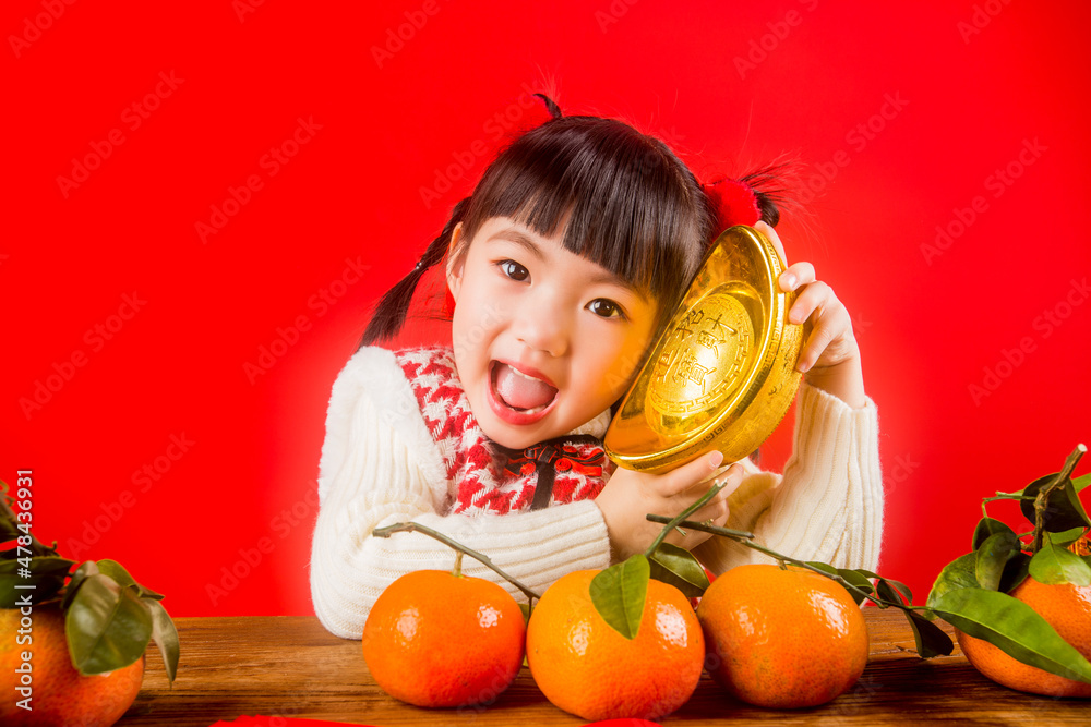 A Chinese girl celebrates the Spring Festival with gold ingots A Chinese girl celebrates the Spring Festival with gold ingots
