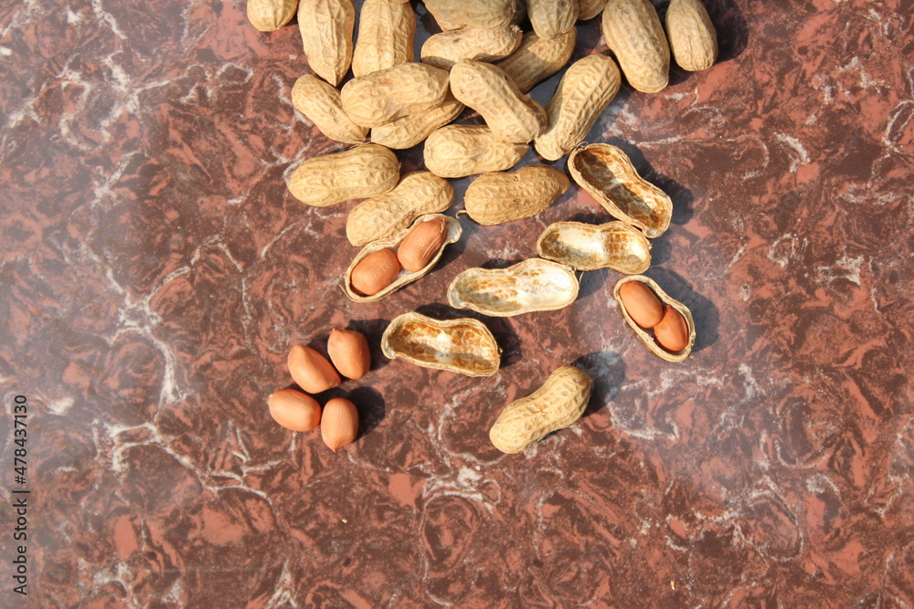 Fototapeta premium Bunch of peeled peanuts on tile view from above