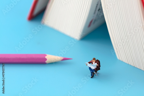 Fotografie Reader on pencil next to miniature creative book