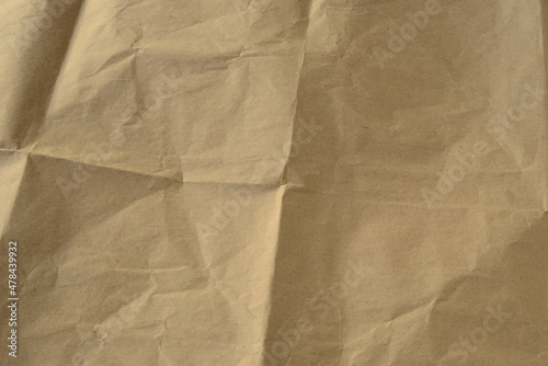 Background from sheet crumpled brown kraft paper. Old paper surface. Rumpled brown cardboard paper