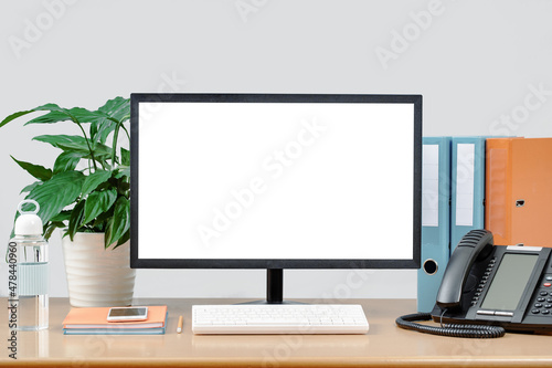 traditional modern office desk with mockup monitor screen, supplies and ip phone. Water bottle. Binders and plant. working from home