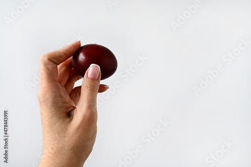 woman's hand holds an Easter colored egg isolated on a white background. Space for text