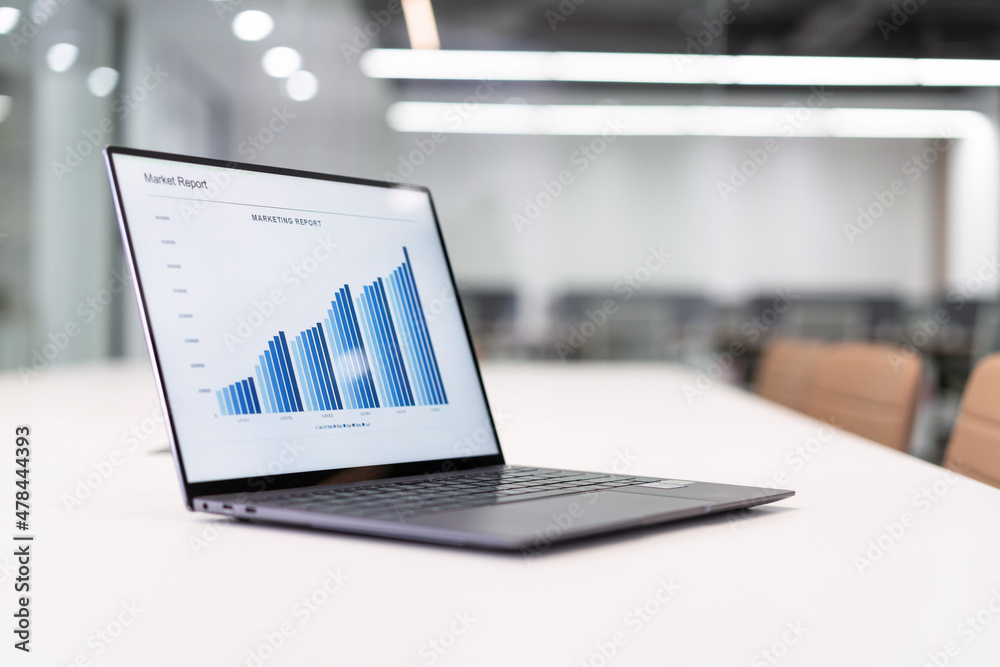laptop with finance reports on desk in modern office laptop with finance reports on desk in modern office