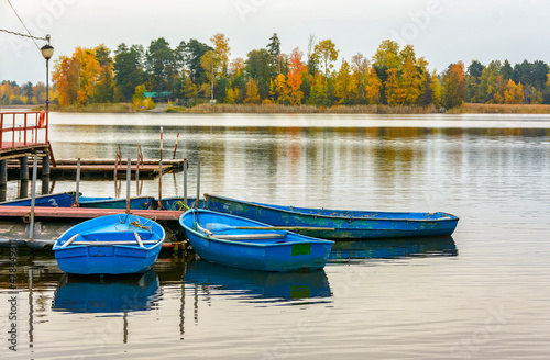 An old wooden pier on the shores of Lake Vuoksa with boats tied to it.