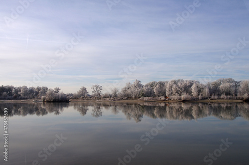 Winterliche Landschaft. Mit Frost überzogene Bäume spiegeln sich im See © cuhle-fotos
