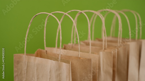 Eco-friendly Paper package bags for shopping or delivery isolated on green background. People lifestyle concept
