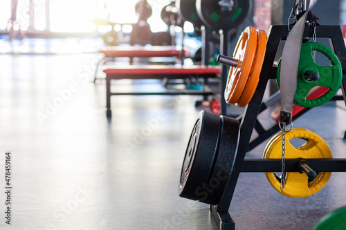 Photography Close up of multicolored weight plates on the bar of gym