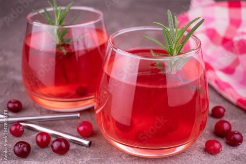 Cranberry vitamin cocktail with a sprig of rosemary.
Close-up.