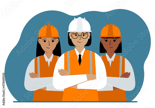 A team of smiling construction workers in white and orange helmets and orange vests. Engineer and builders.
