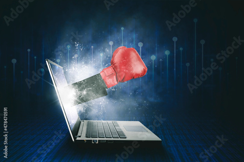 Businessman hand punching from laptop screen