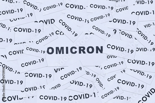 Close up of omicron word with pile of covid-19 text