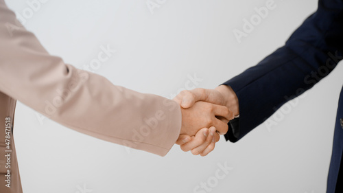 握手をするビジネスマンとビジネスウーマン