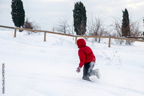 Child running in a field full of snow. 