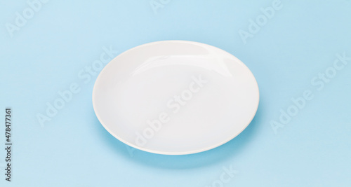 Empty white plate on blue background