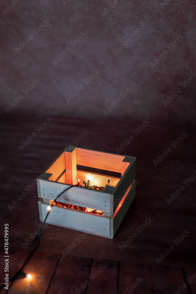 Fototapeta premium wooden box with garland on bold background